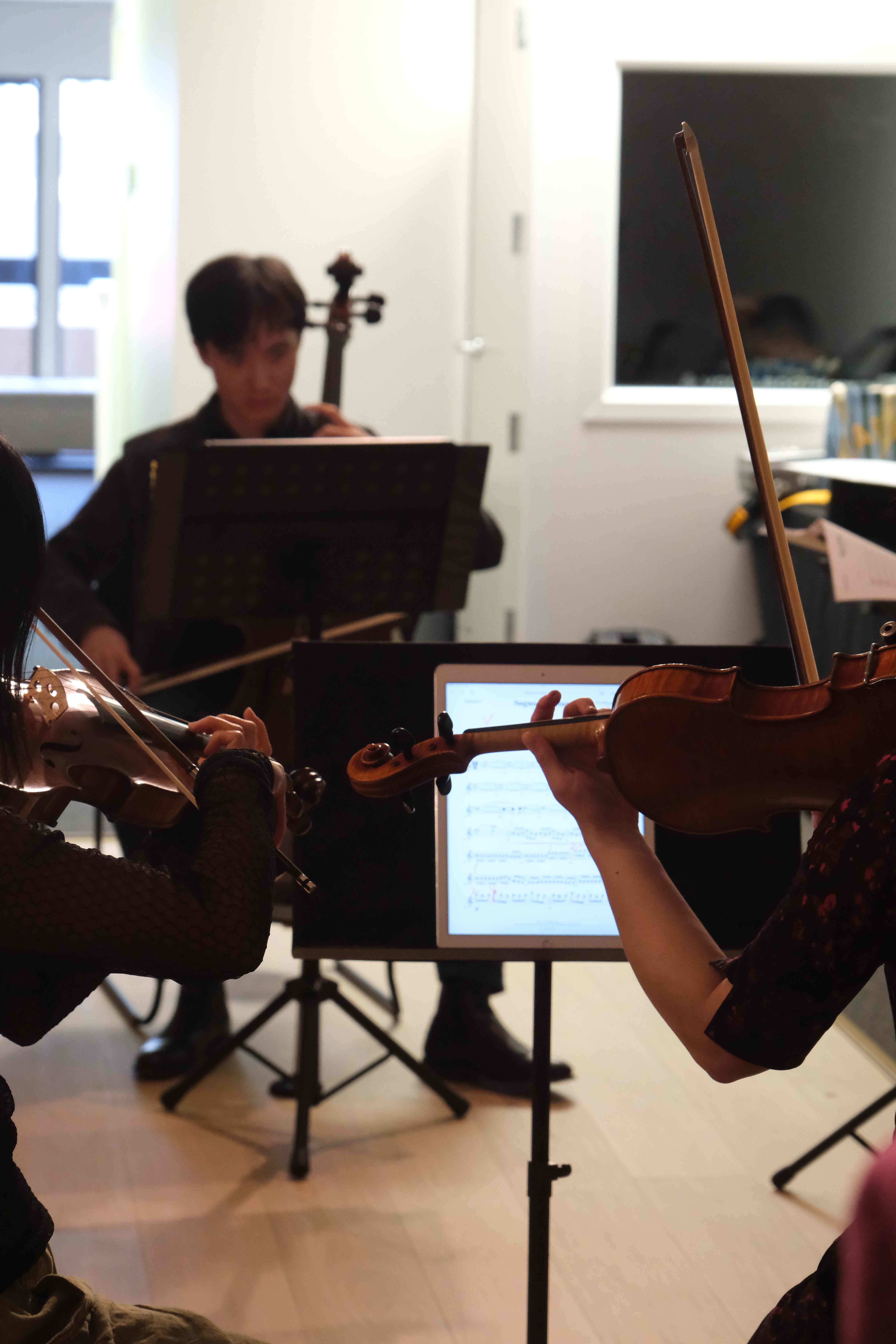 Violinists rehearsing with tablet sheet music