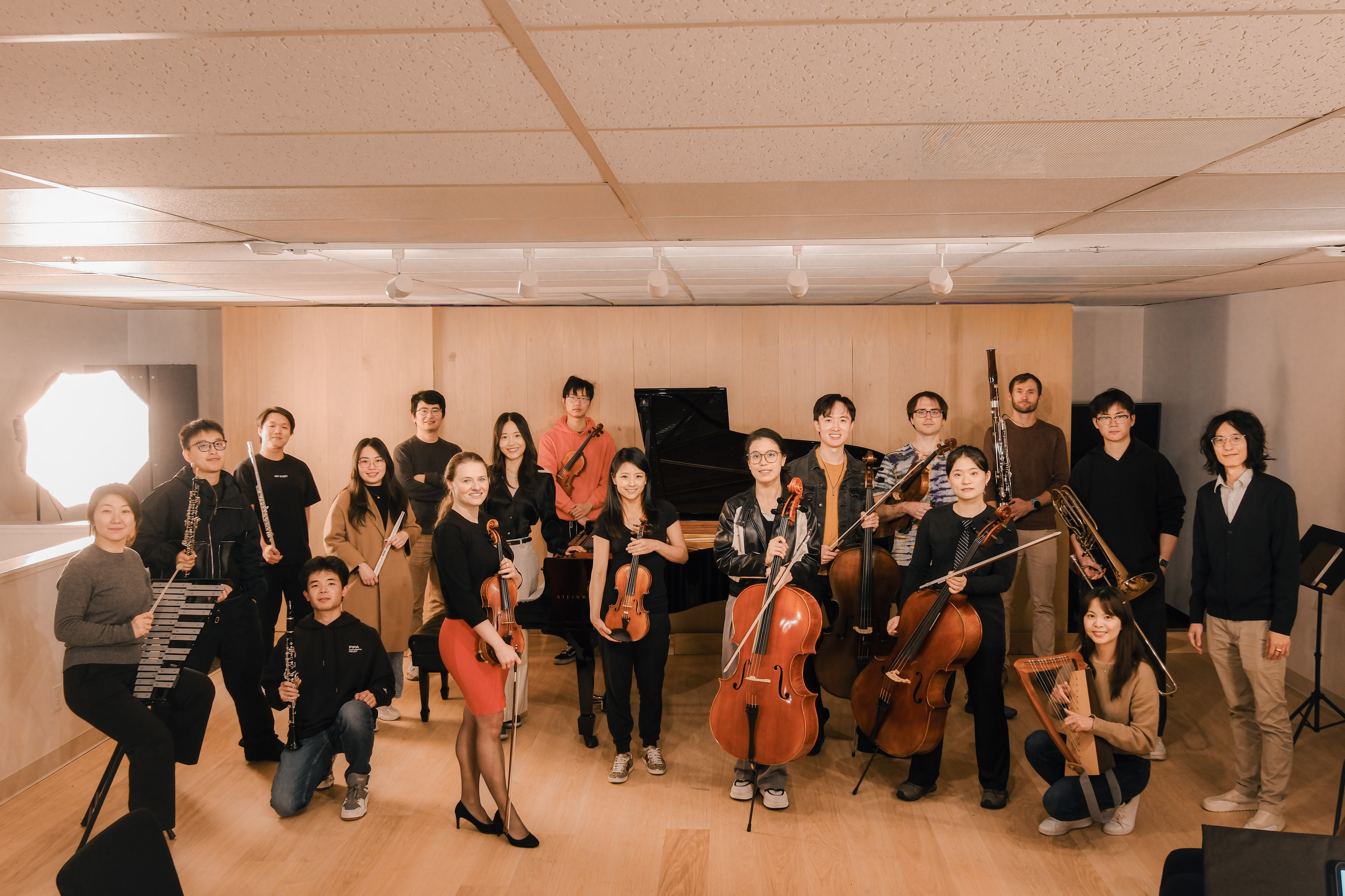 GG Orchestra ensemble members posing together in studio with their instruments